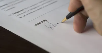 Persona firmando un documento con un bolígrafo