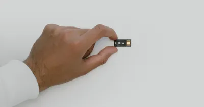 Mano sosteniendo una llave USB de seguridad con el dibujo de una llave