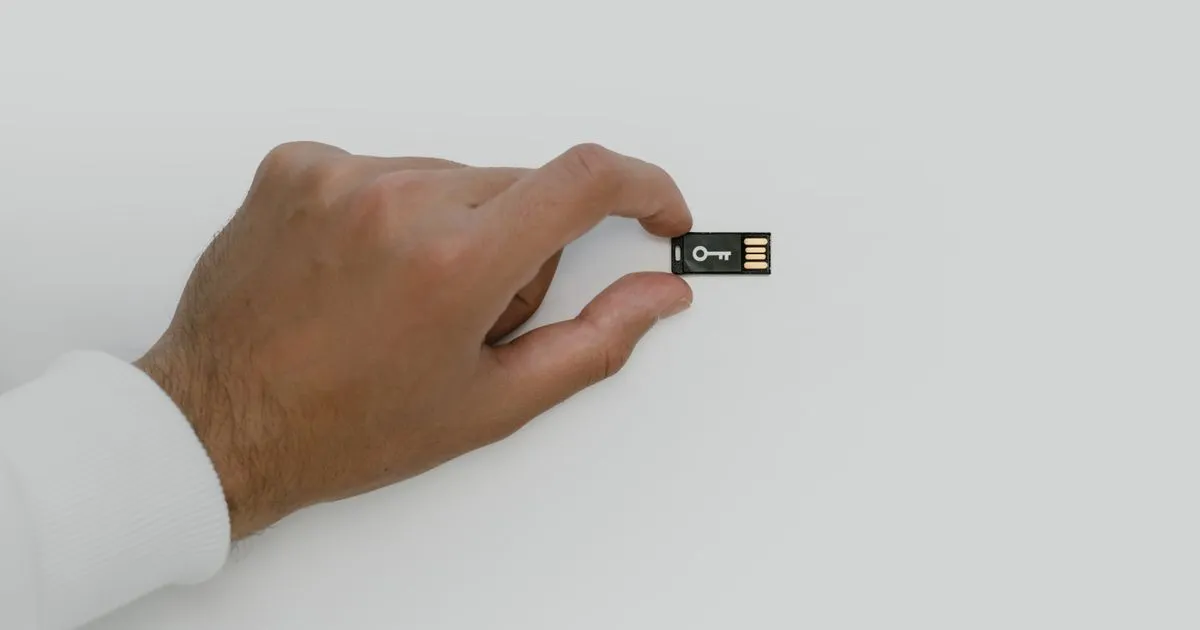Mano sosteniendo una llave USB de seguridad con el dibujo de una llave