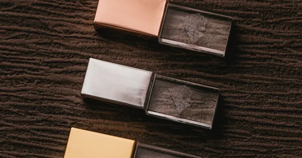 Tres dispositivos USB con carcasa metálica alineados sobre una superficie de tela oscura